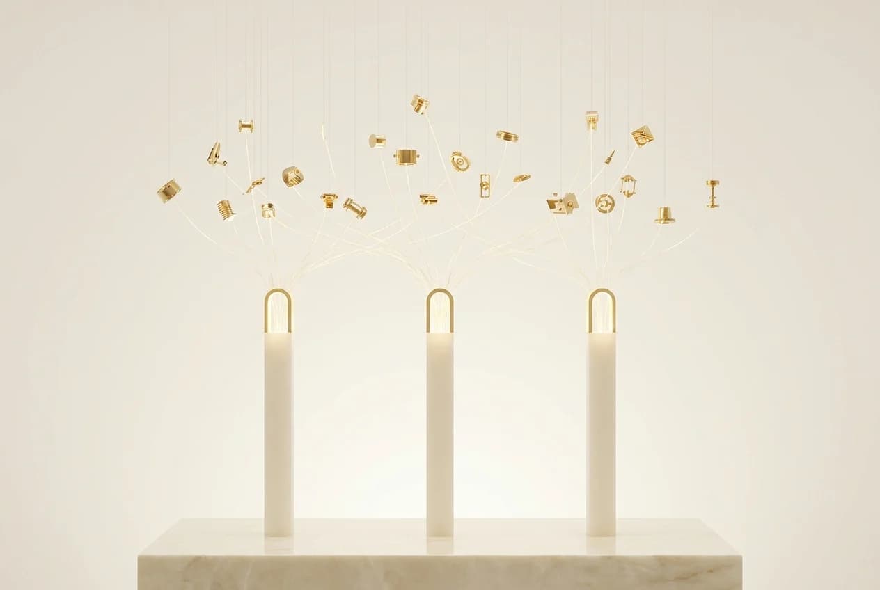 Constellation de nœuds d'or reliés par des filaments lumineux convergeant vers trois piliers d'or sur fond ivoire : la valeur se concentrant sur quelques péages d'une économie de machines, direction artistique blanc et or de Byss Group
