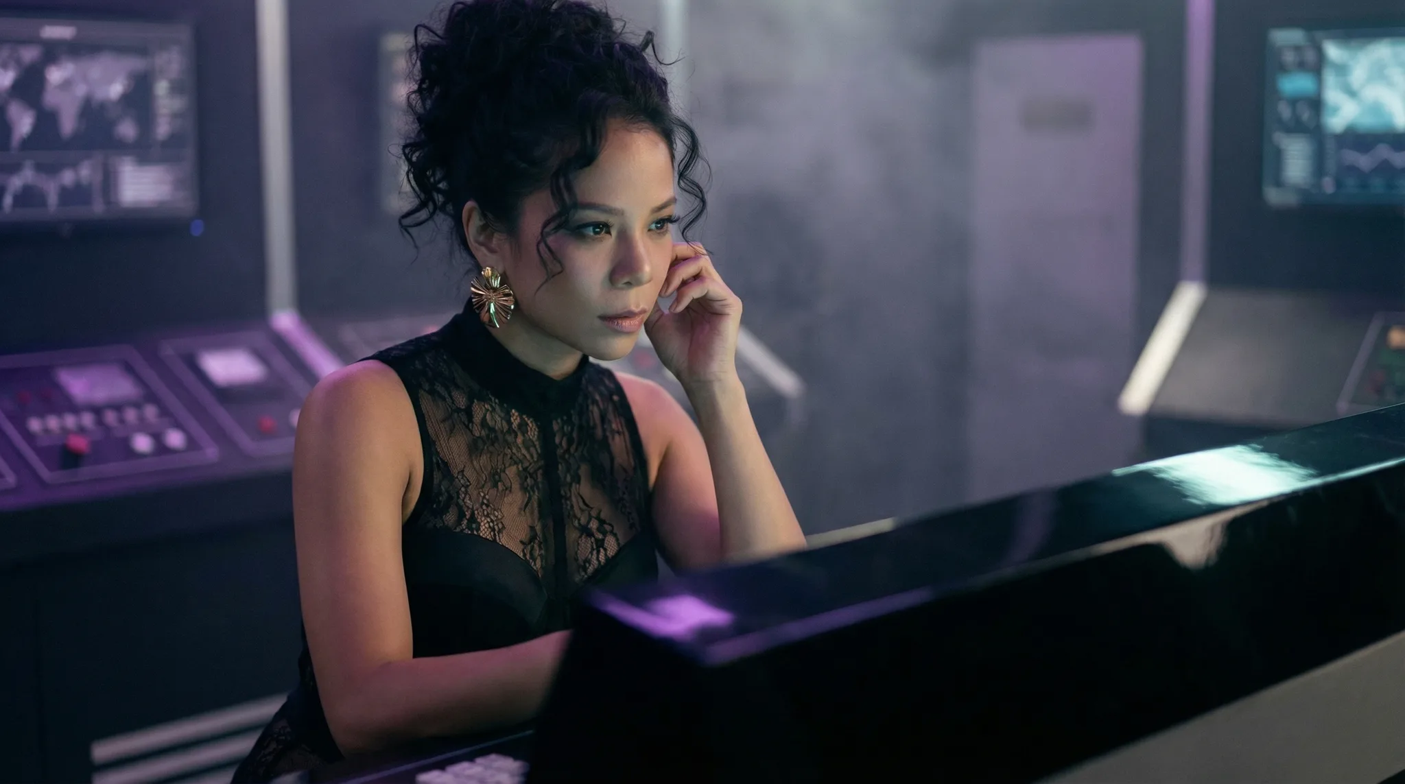 Opératrice en robe de dentelle noire au standard d'une console violette, écrans de contrôle en fond — image de la série Jurassic Wars, produite par Byss Group